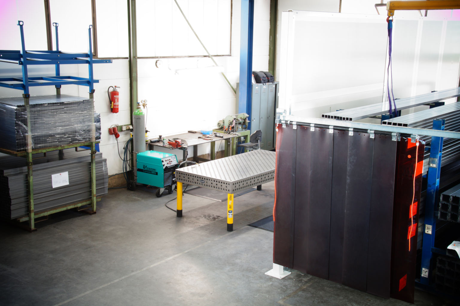 Teleskopierbarer und schwenkbarer Schweißschutzvorhang an einer Lärmschtzwand befestigt